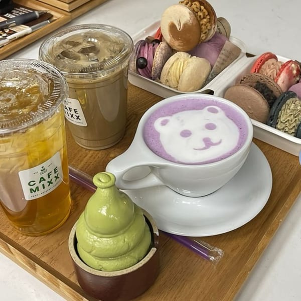 Cafe Mixx drinks and desserts, including a purple latte with bear art, iced tea, coffee, and macarons.