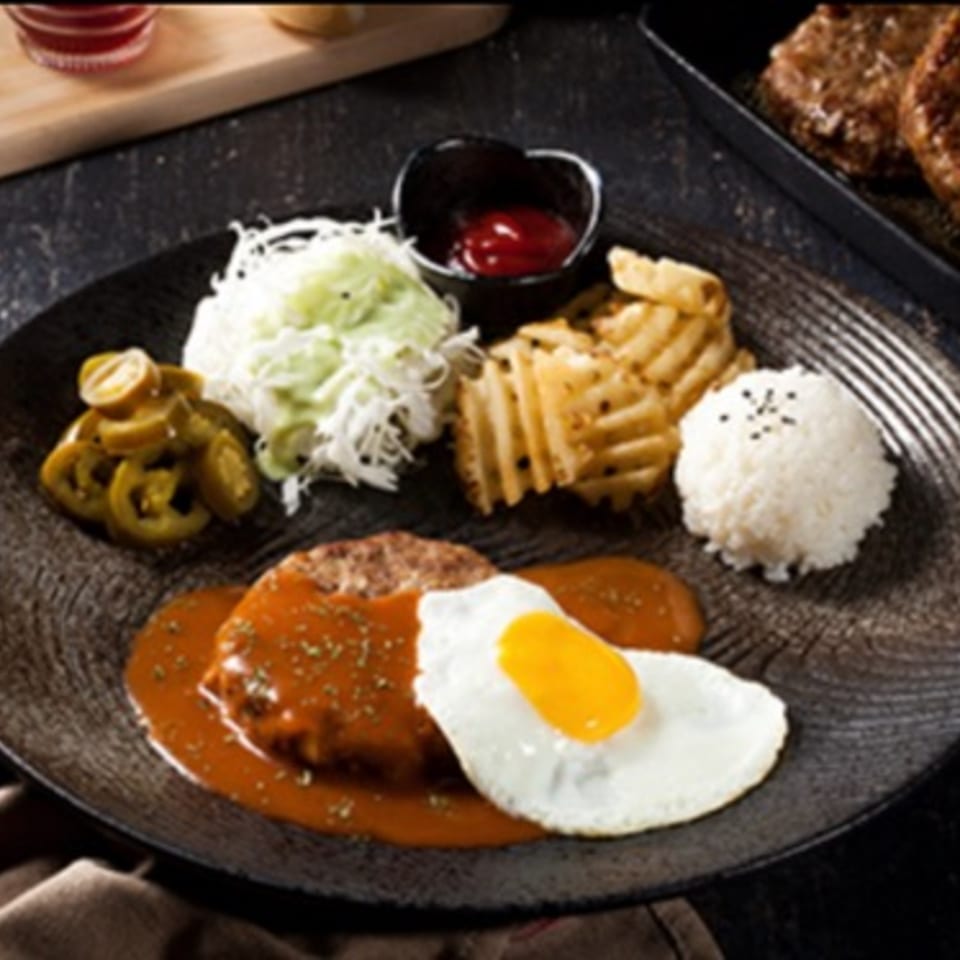 Cafe Mixx's hamburger steak with gravy, fried egg, rice, waffle fries, coleslaw, and pickled jalapeños.